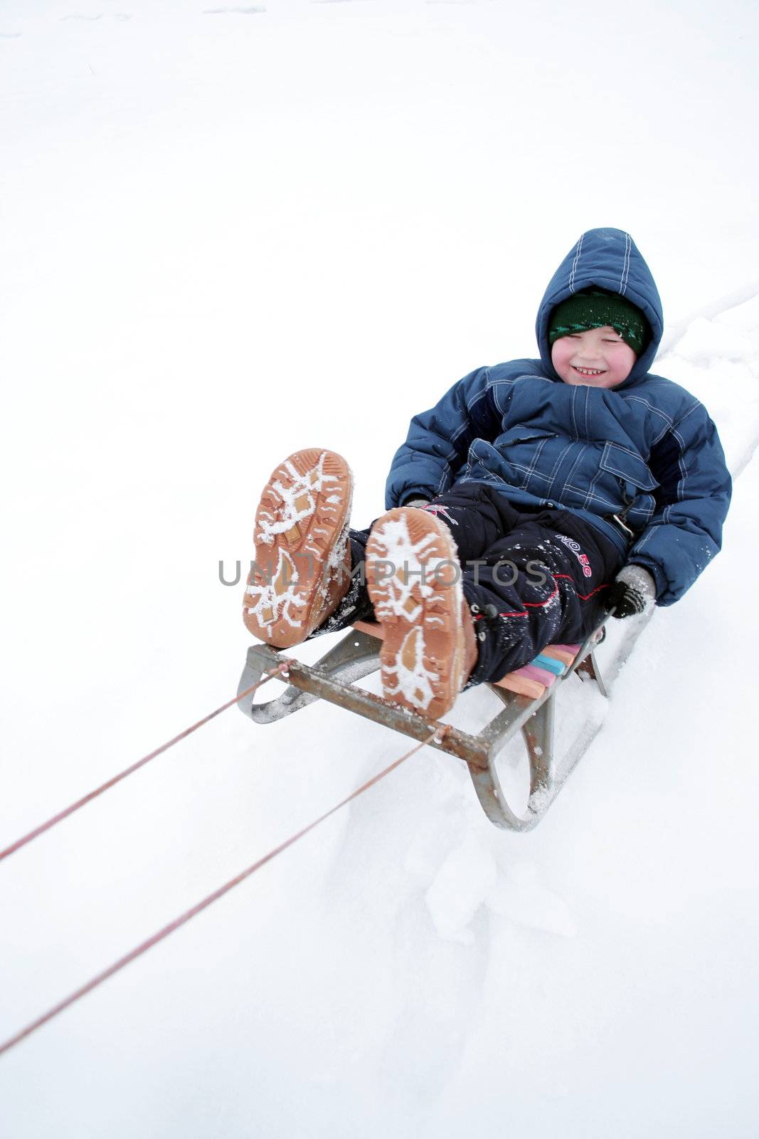 Winter riding of the boy on sled