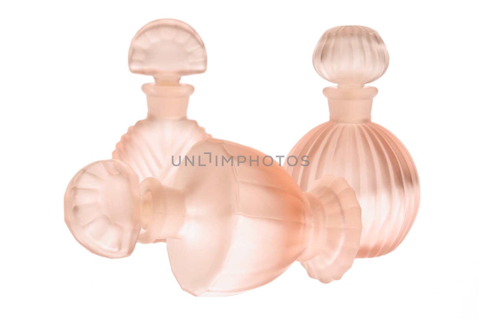 Three empty pink glass bottles isolated on white