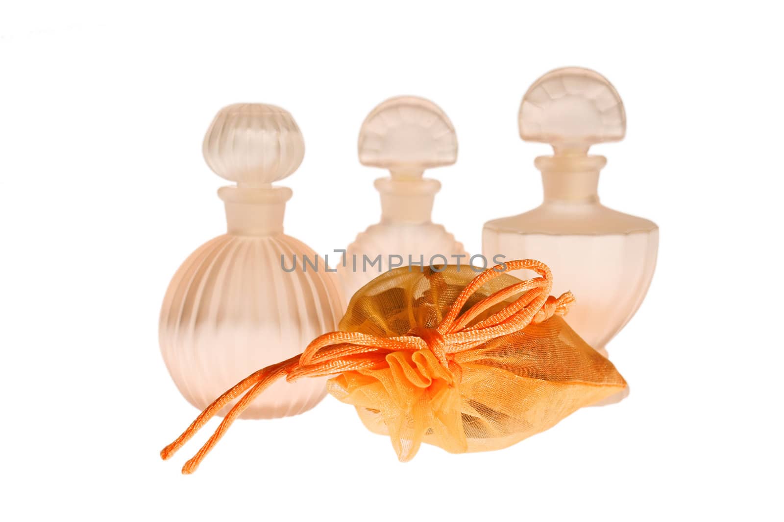 Potpourri sachet and three empty glass bottles isolated on white. Focus on potpourri sachet.