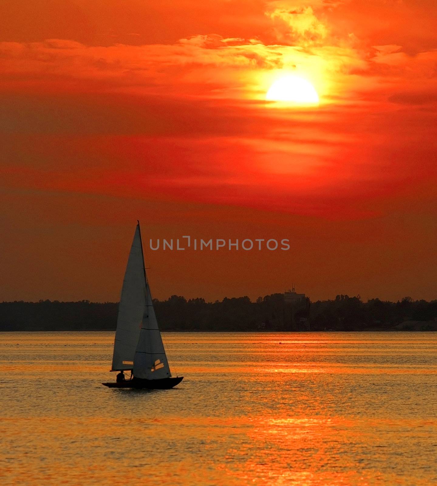 Beautiful seascape with yacht sailing into sunset.