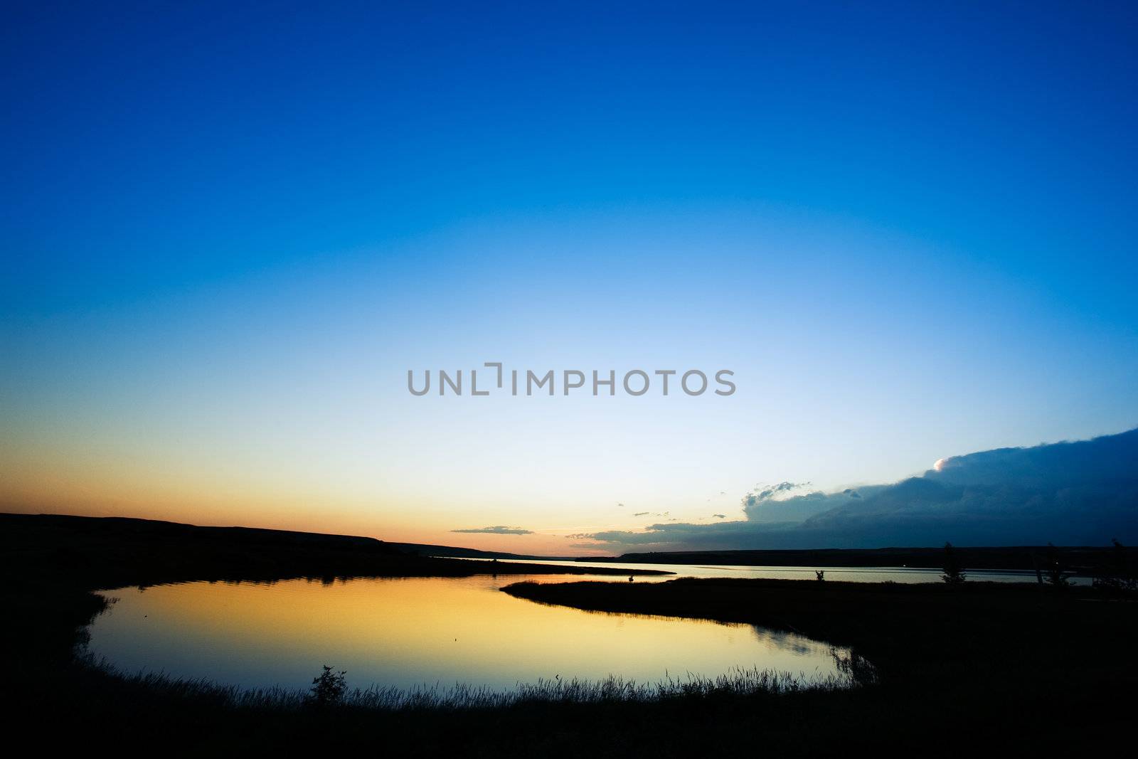 A sunset on a lake in rural saskatchewan