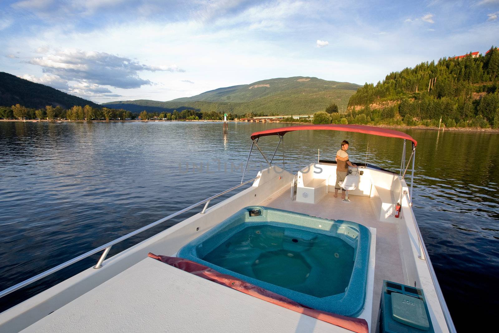 A young male at the helm of a luxury boat