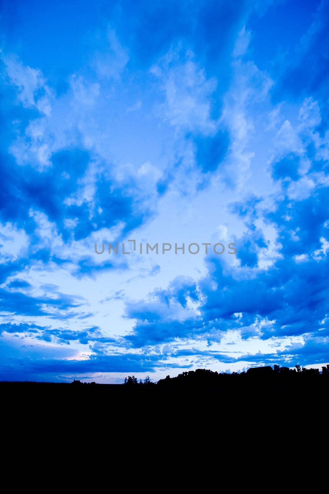 A blue evening sky with clouds on the prairie