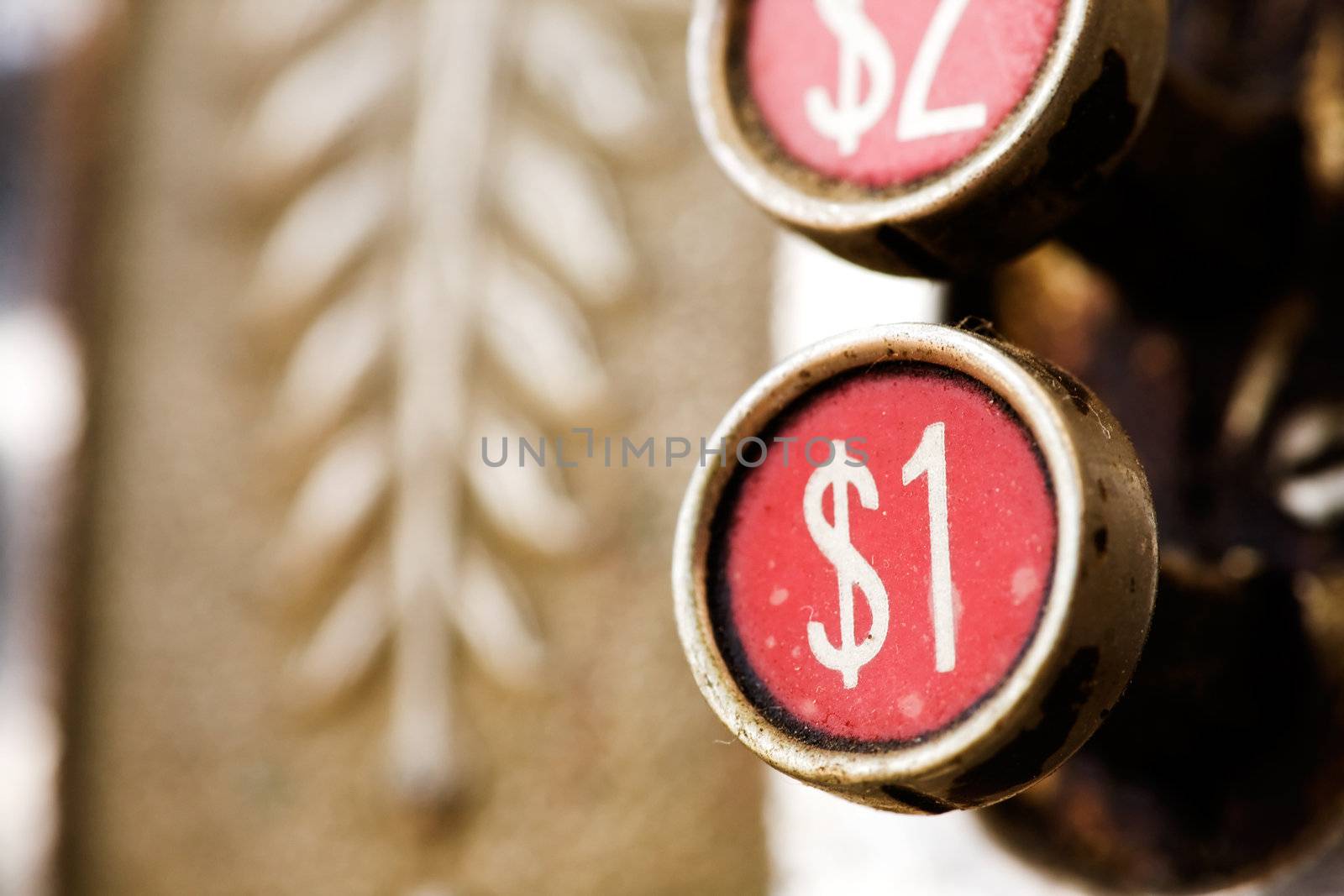 A one dollar button on a retro cash register - shallow depth of field.