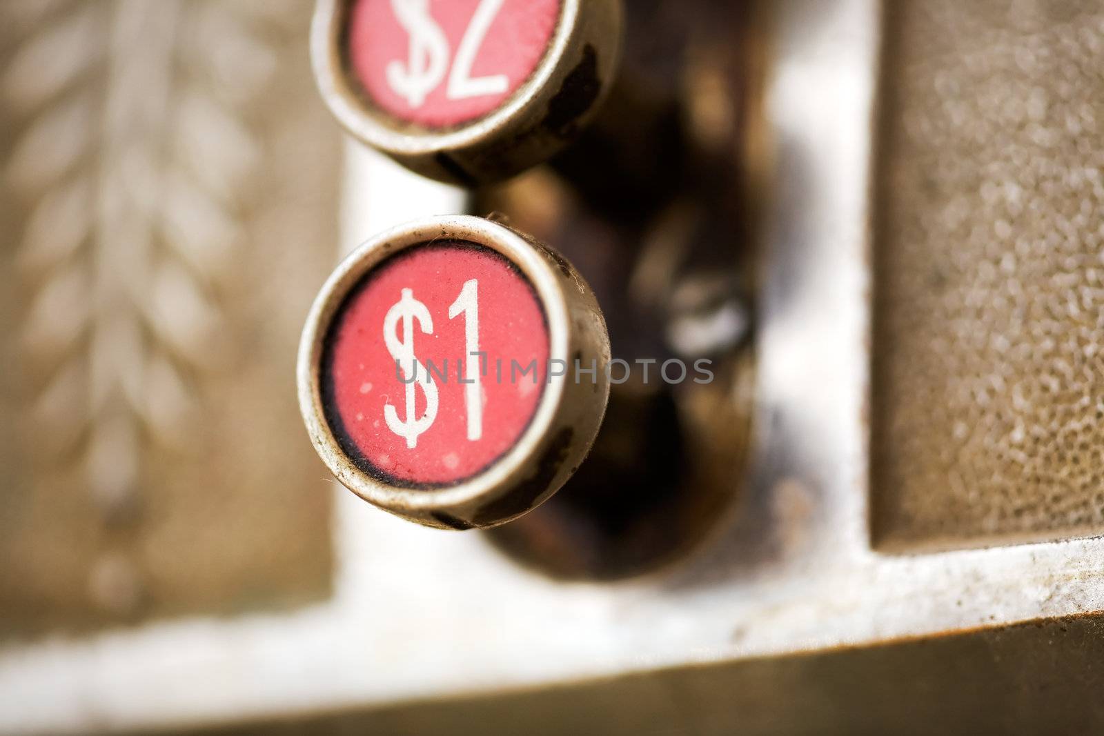 A one dollar button on a retro cash register - shallow depth of field.