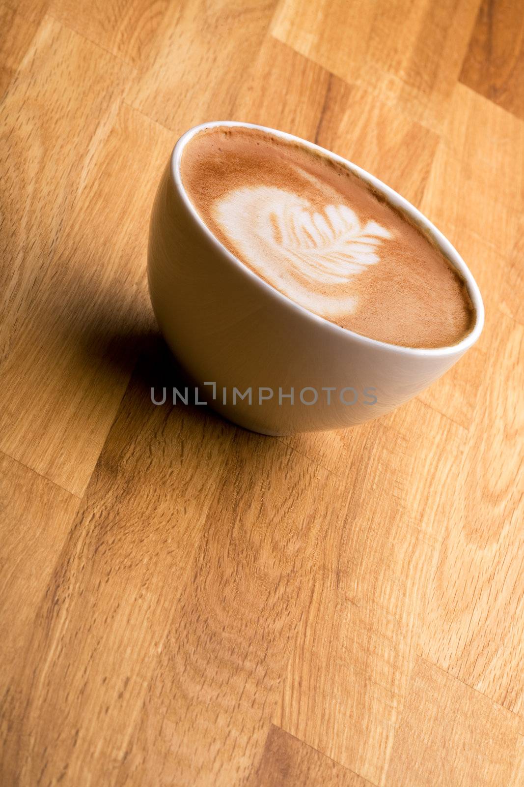 A cappuccino with latte art on a wooden table