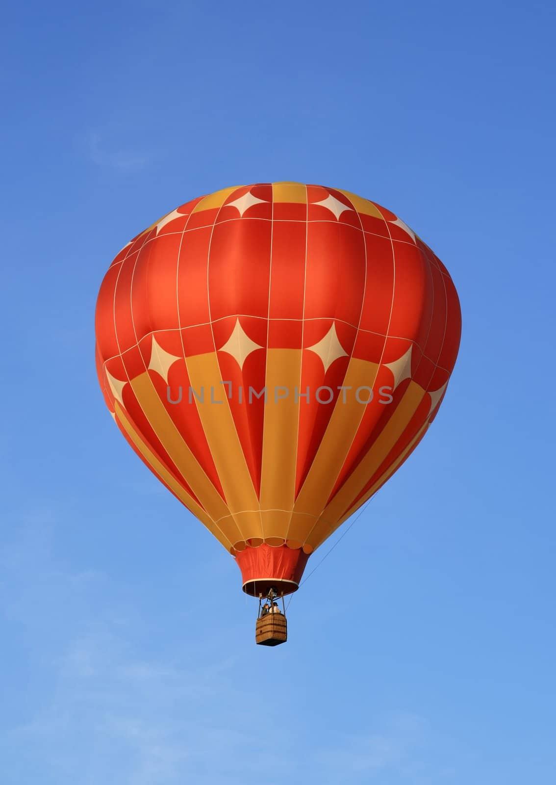 Red and orange hot air balloon in the blue sky.