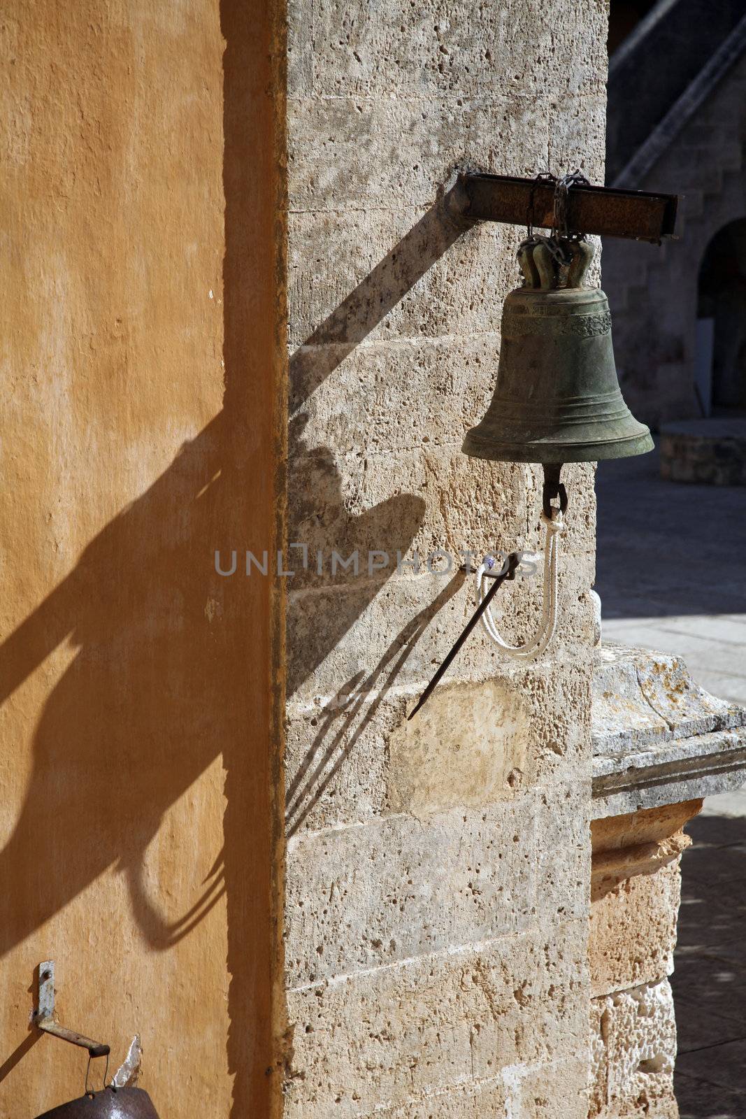 an old bell on a wall at a street of crete