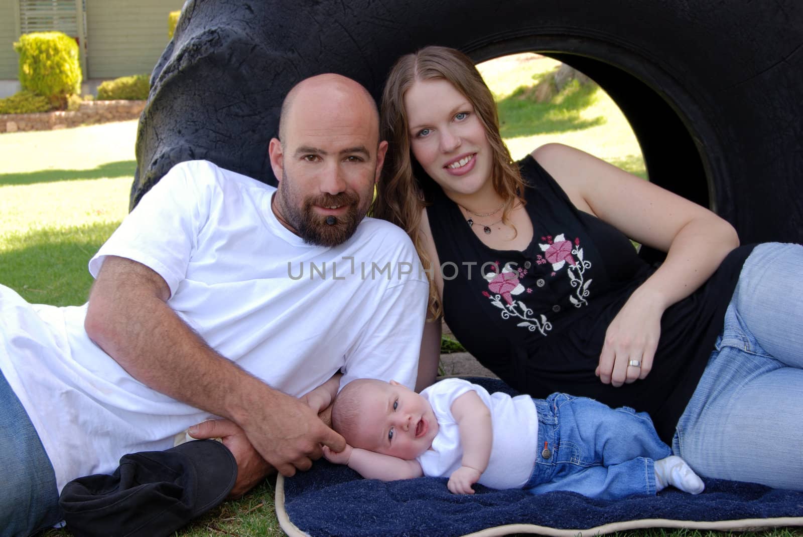Horizontal image of a young modern family of three enjoying a casual day in the park.

