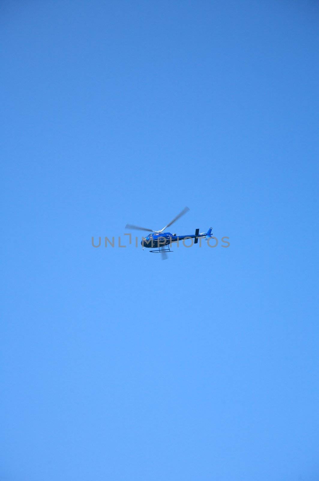 blue helicopter flying at the blue sky of Canary Islands spain