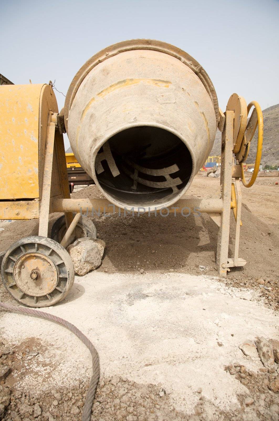 front view of a yellow working cement mixer