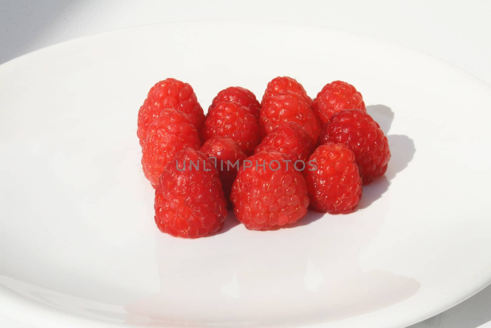 Grouping of raspberries on white plate
