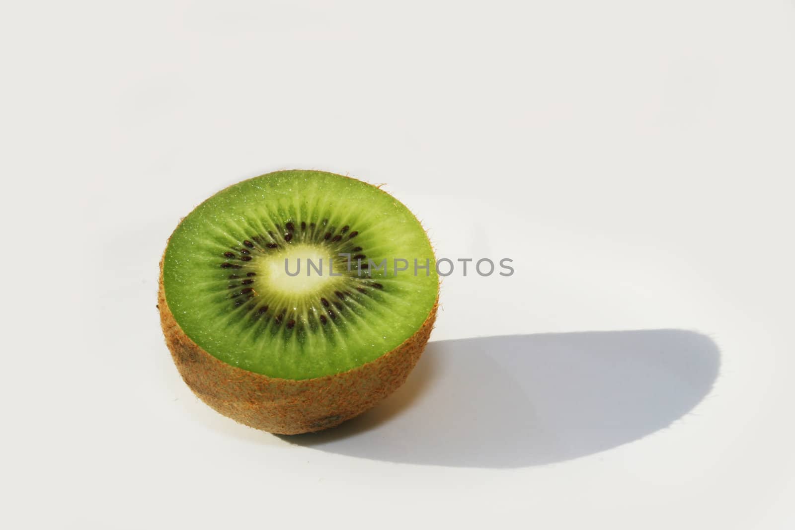 Half kiwi fruit against white background