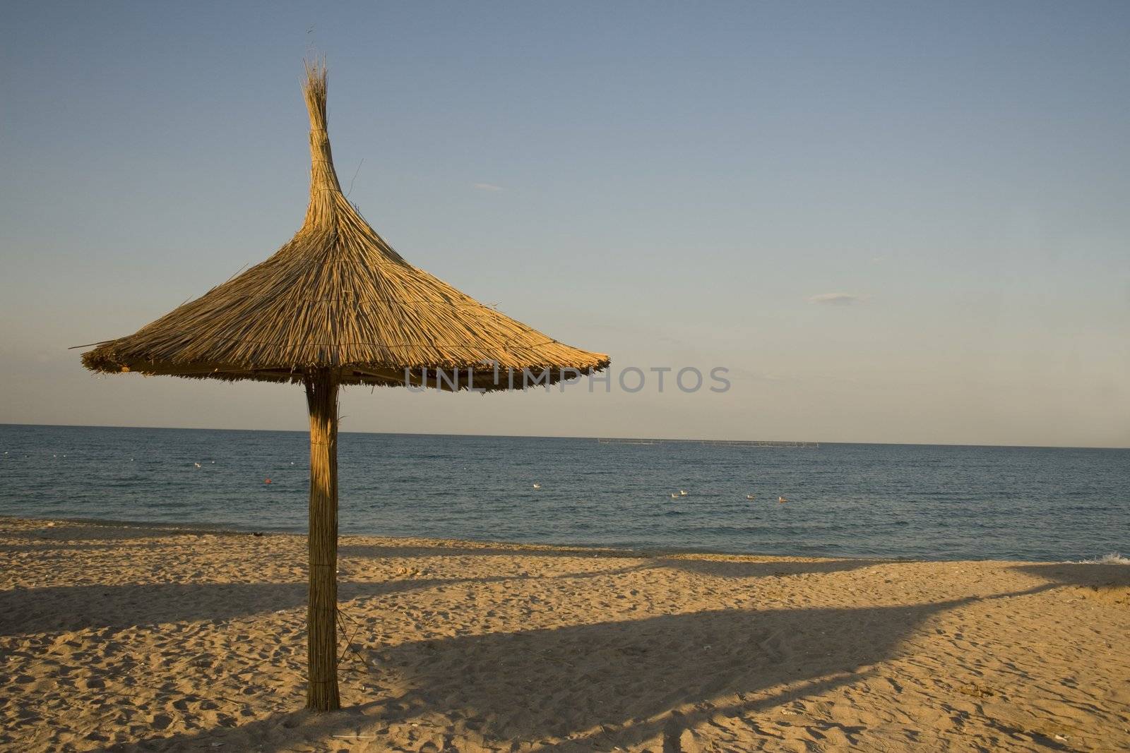 Wood and reed umbrella on picturesque tourist beach