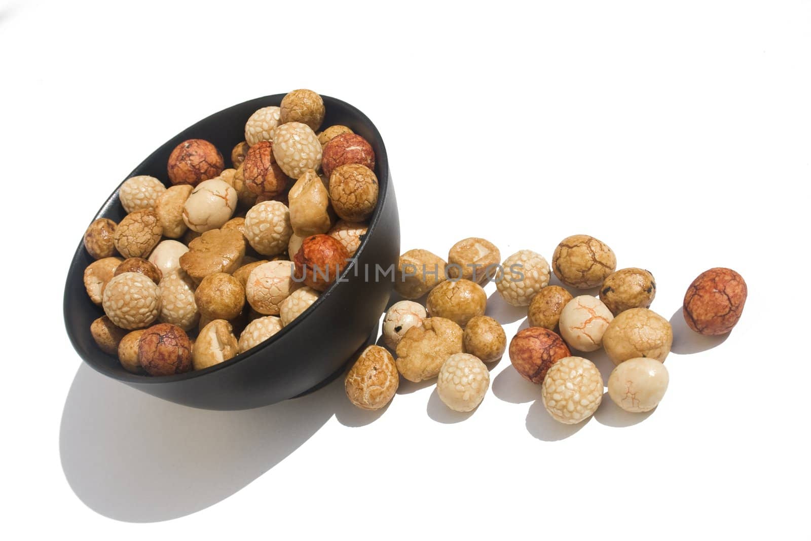 Bowl of Asian rice and sesame crackers against white background