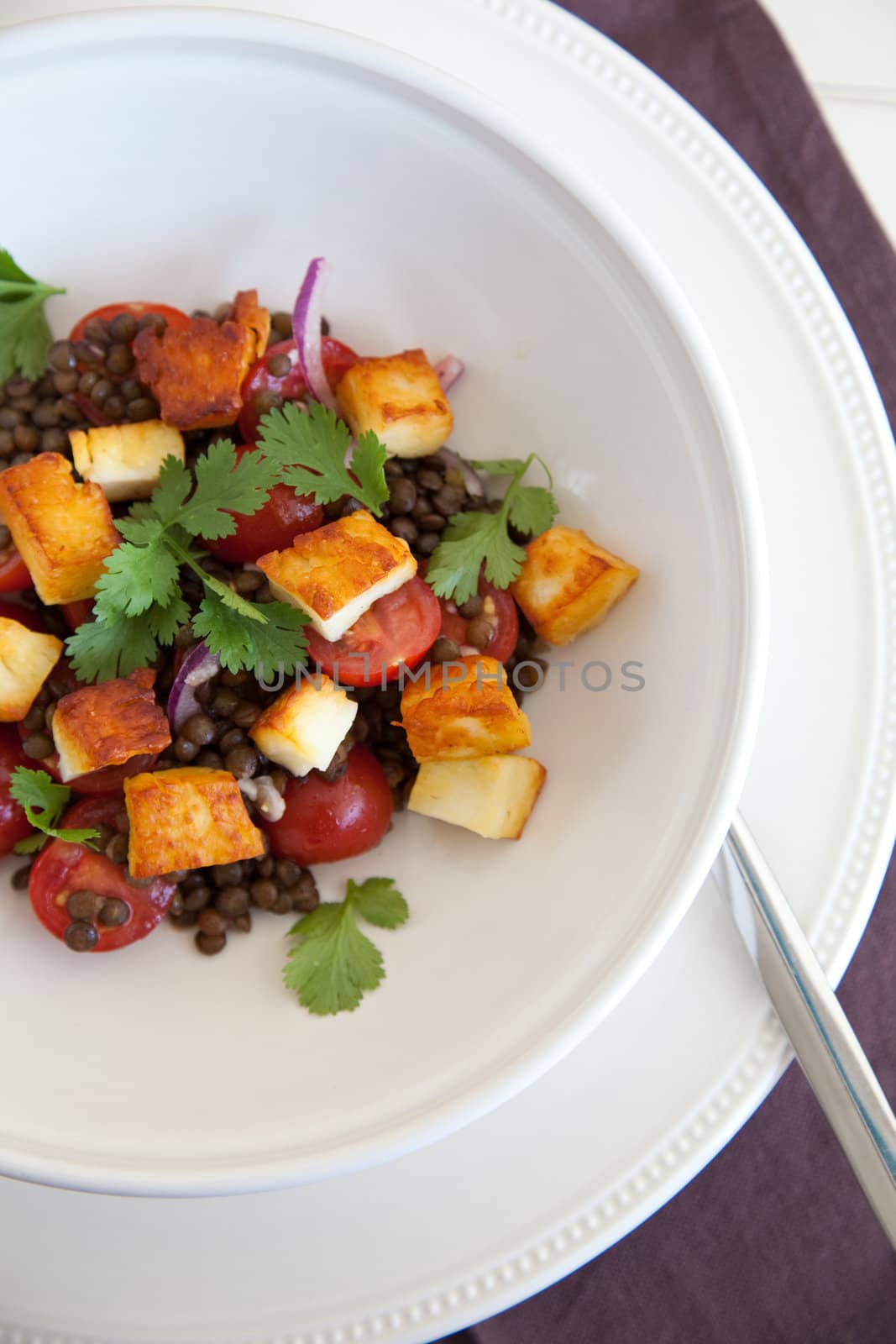 Delicious healthy salad with haloumi, tomatoes, lentils and cilantro