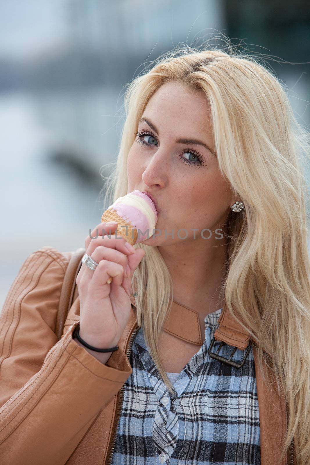Pretty blond girl licking her icecream on a summer day