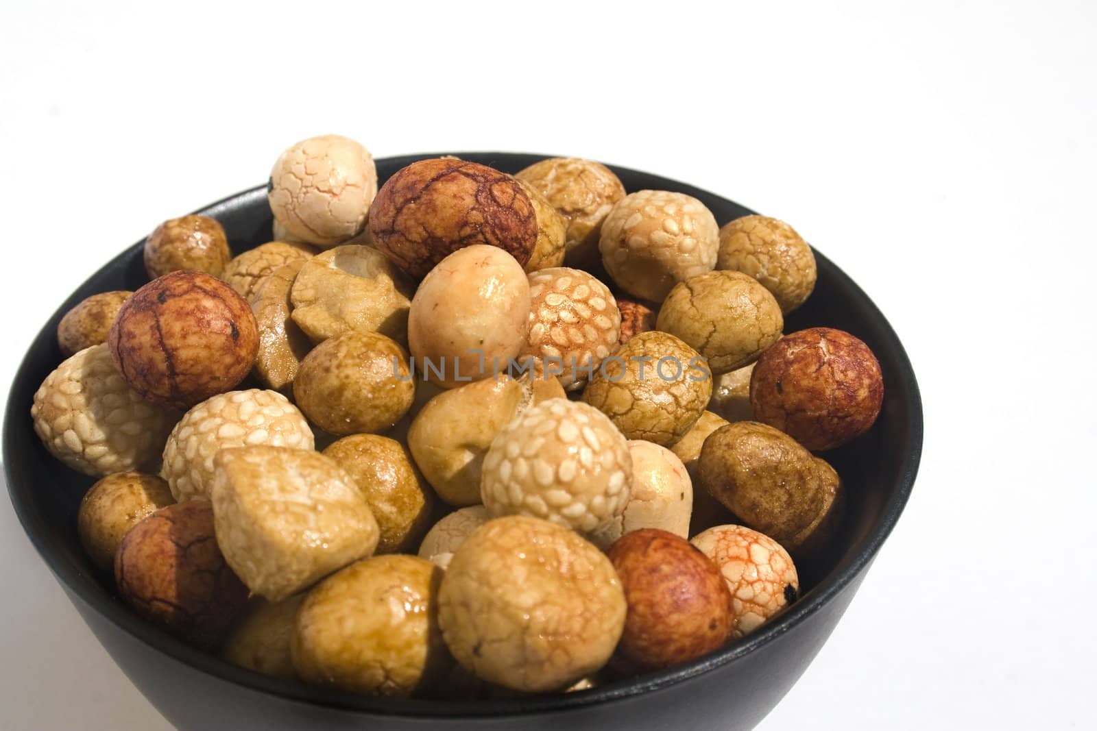 Bowl of Asian rice and sesame crackers against white background