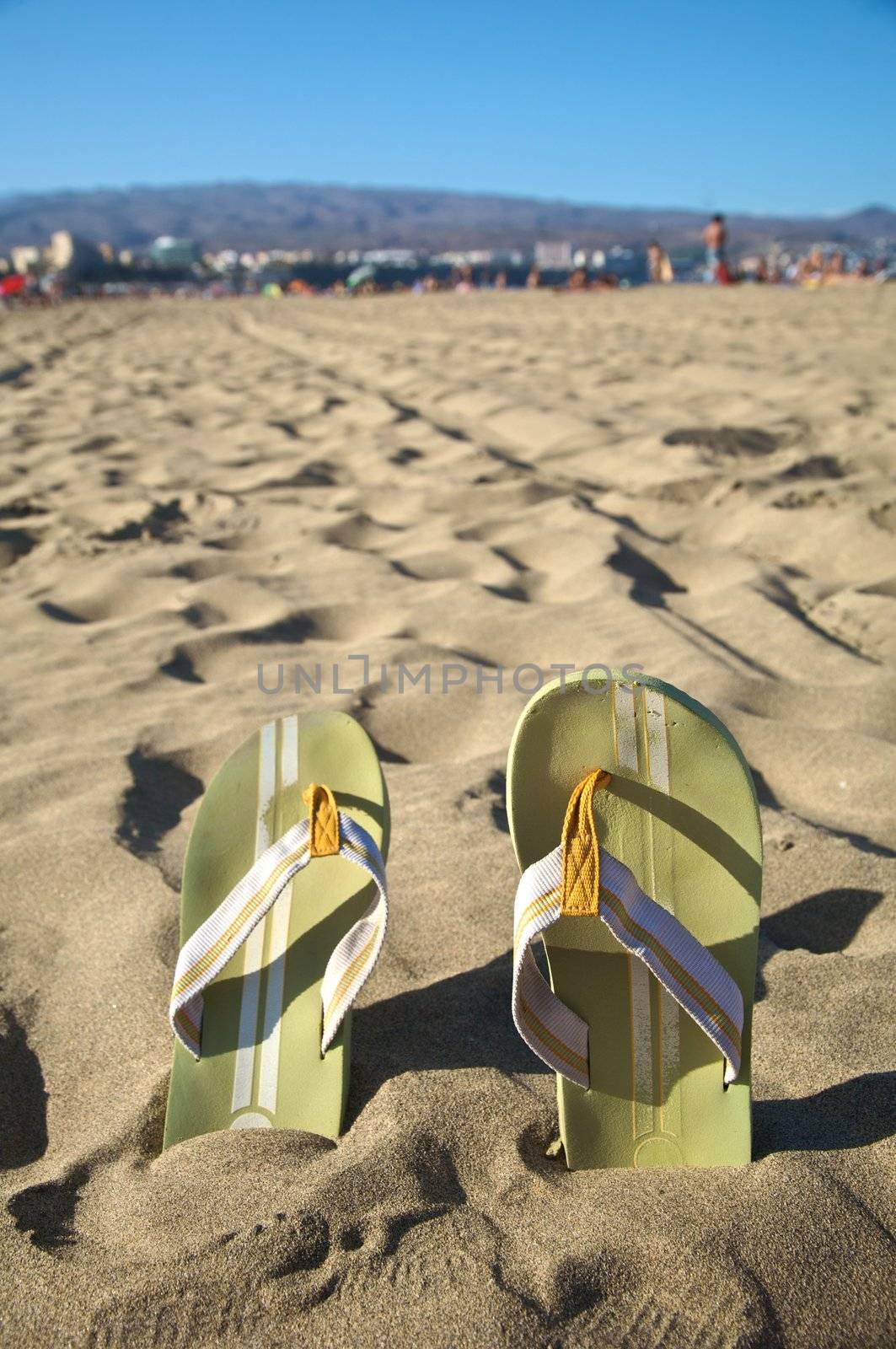 green flip-flop on the sand of a spanish beach