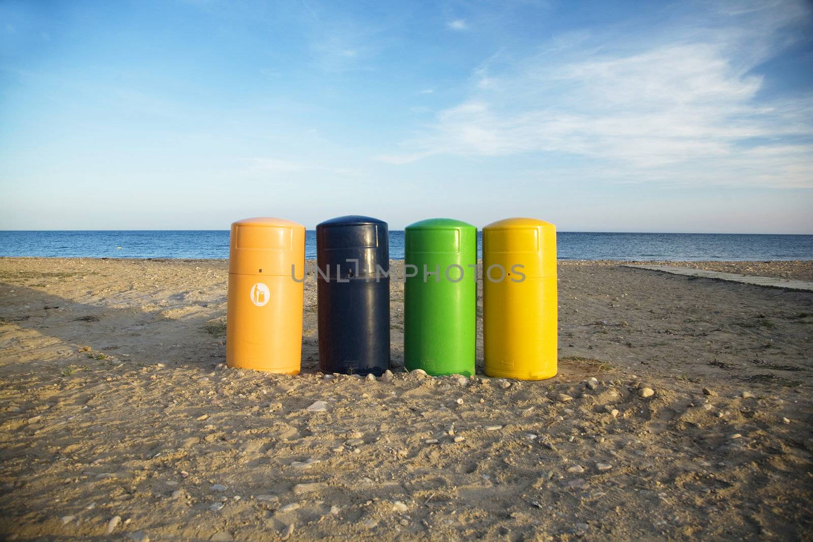 four coloured garbage barrels at the beach of mazarron murcia spain