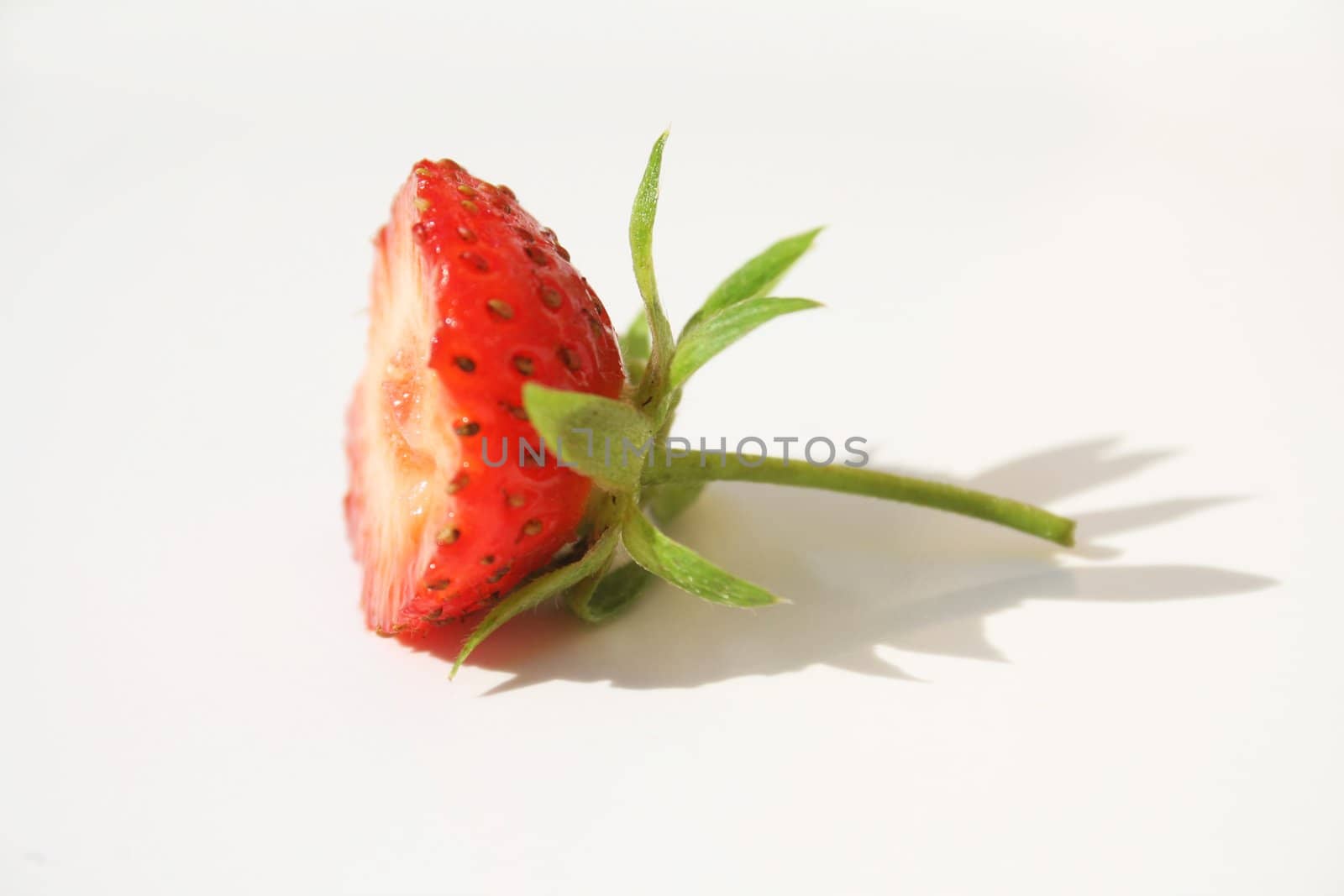 Half of a strawberry on white background with pretty shadow