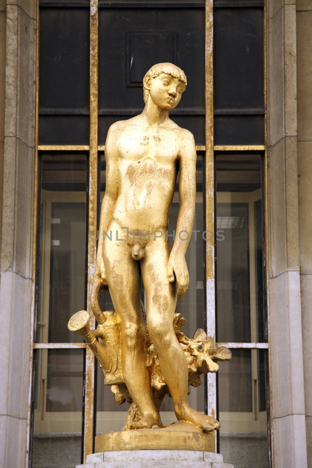 golden statue of a boy next to eiffel tower in paris