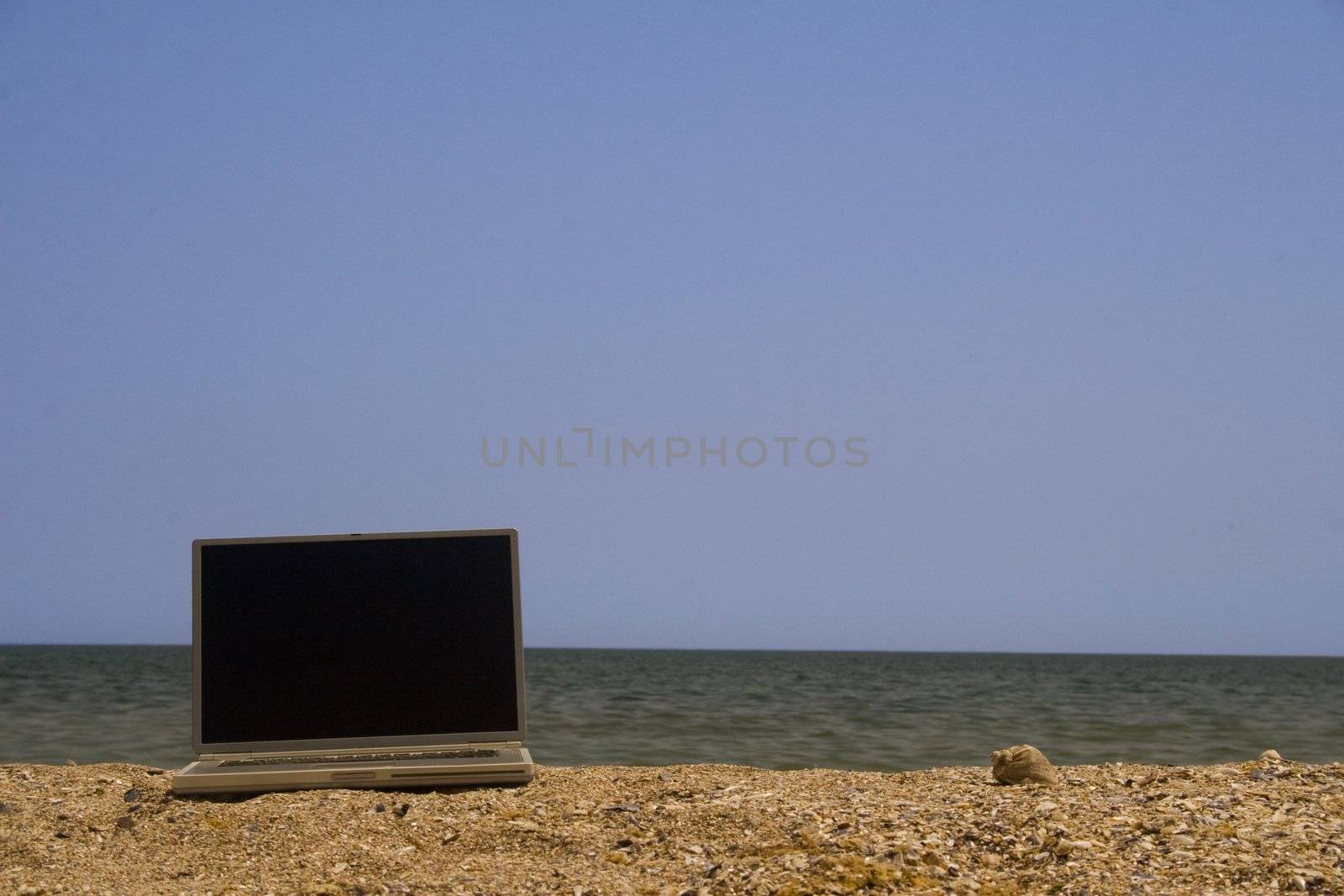 Laptop on beach by timscottrom