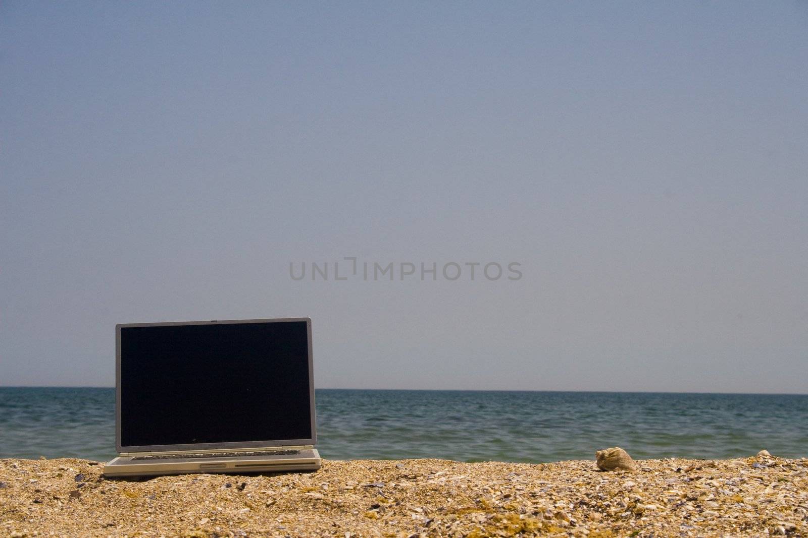 Laptop on beach by timscottrom