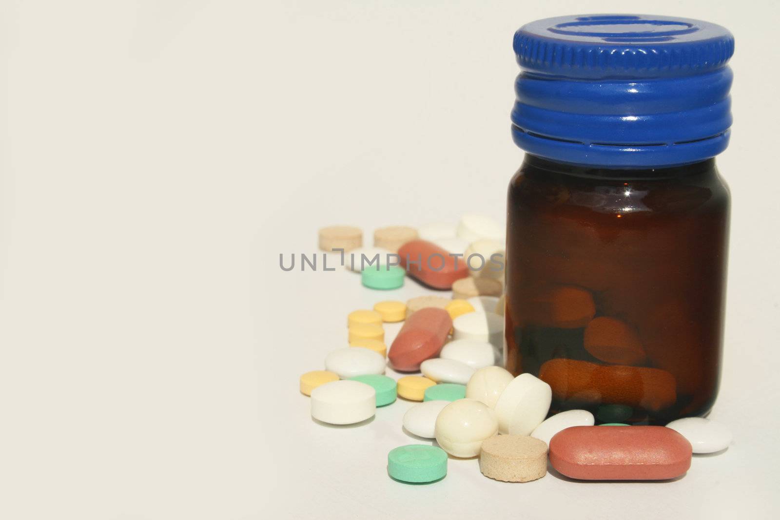 Bottle of pills against white background and ad space on left