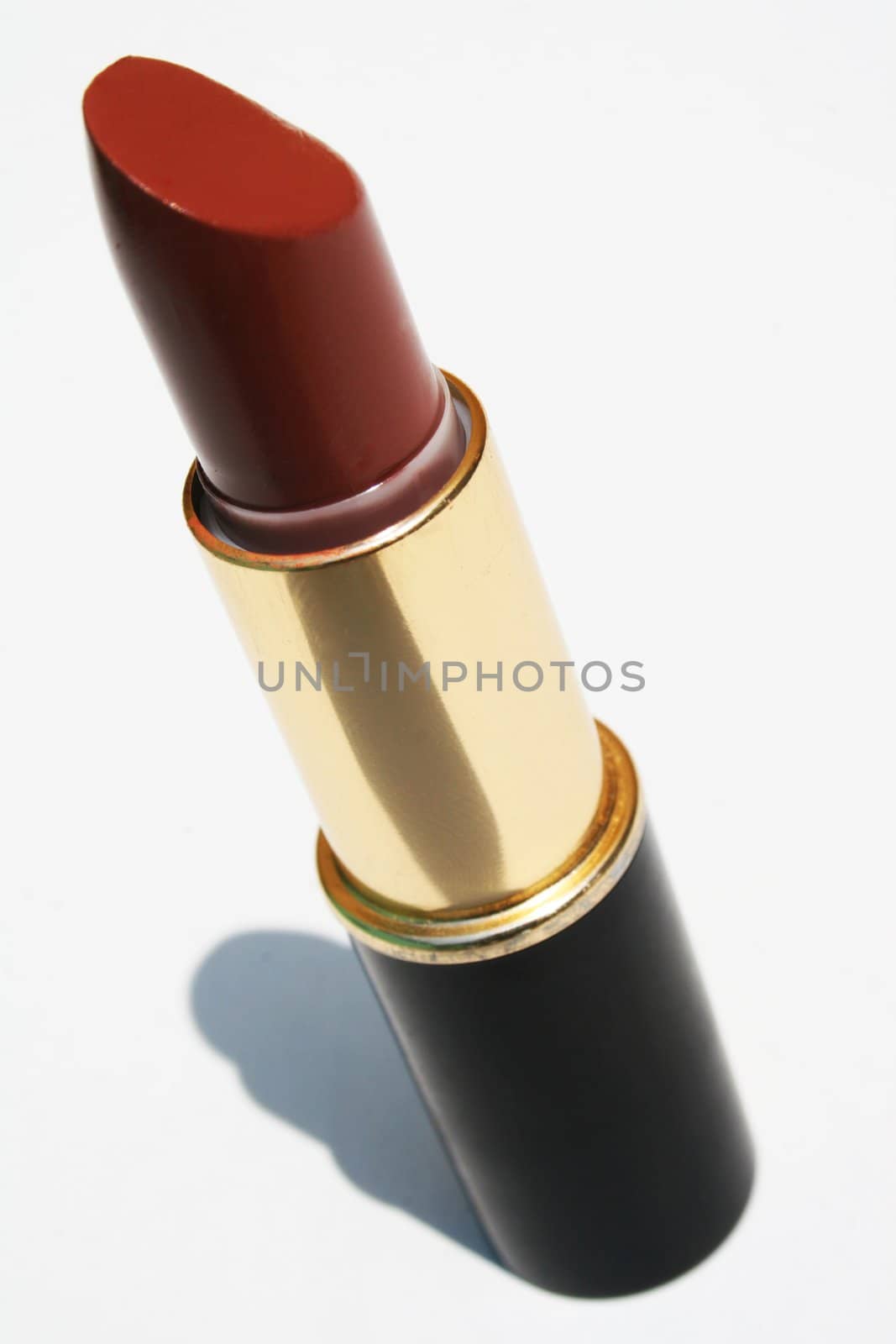 Tube of maroon lipstick against white background