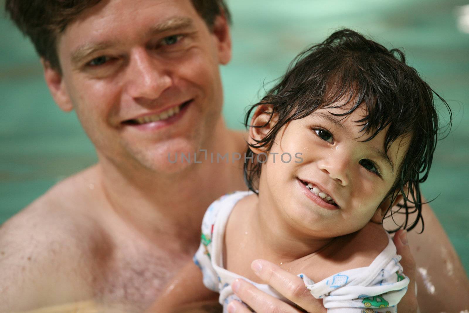 Father and toddler boy swimming by jarenwicklund