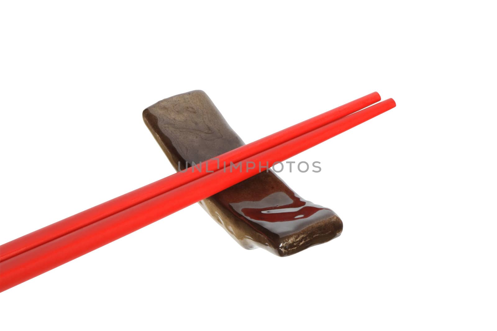 Pair of red chopsticks lying on rests. Isolated on white with clipping path