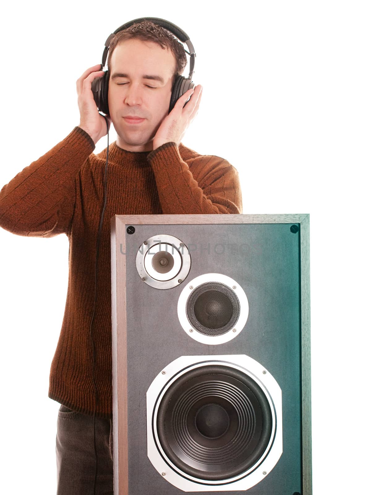 A young man is listening to music with a pair of headphones, isoated against a white background
