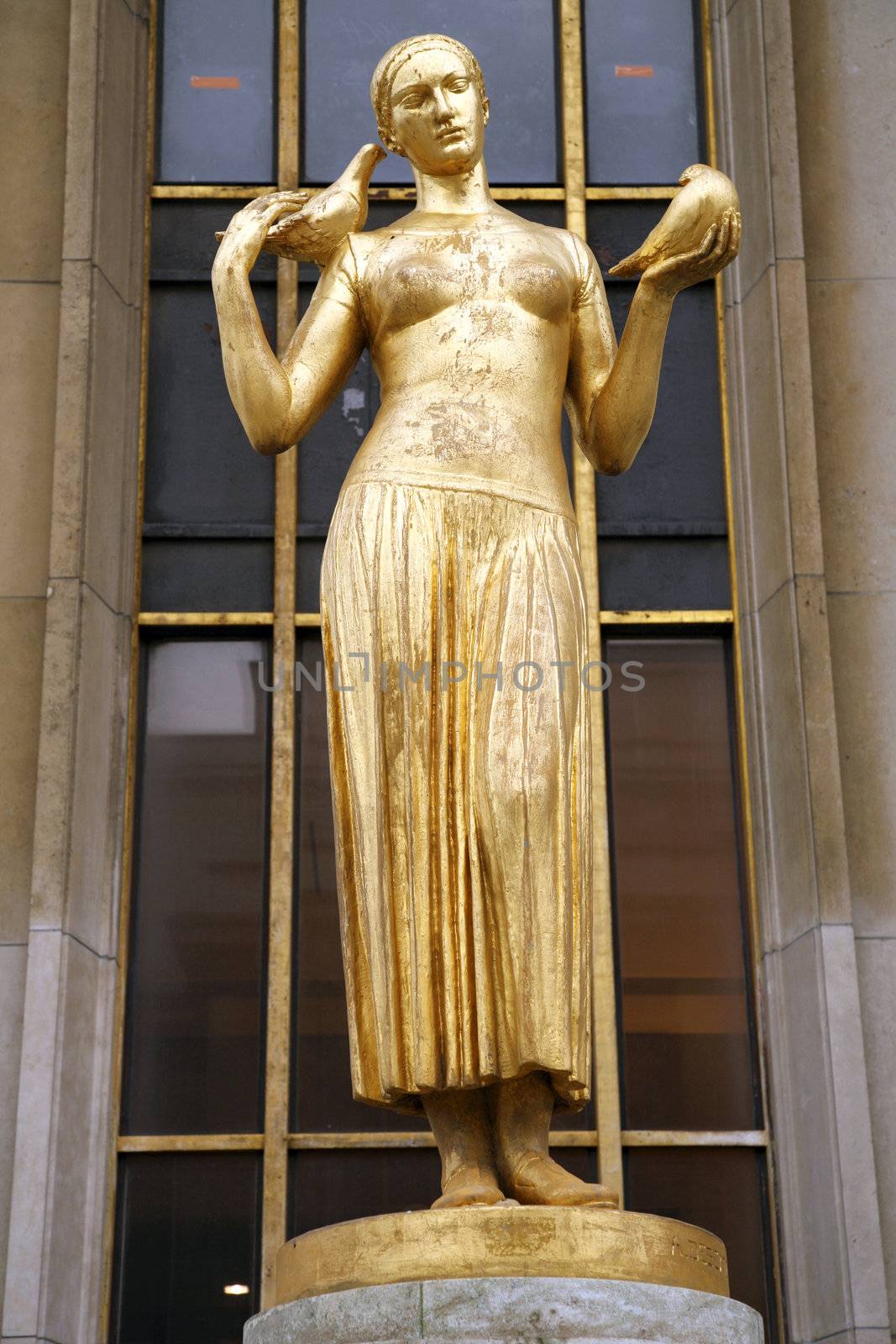 golden statue of a woman next to eiffel tower in paris