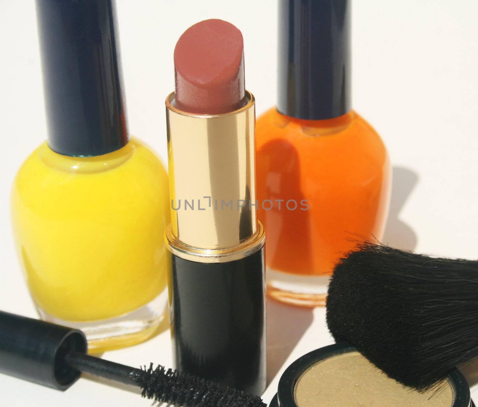 Nail polish lipstick mascara and foundation on white background