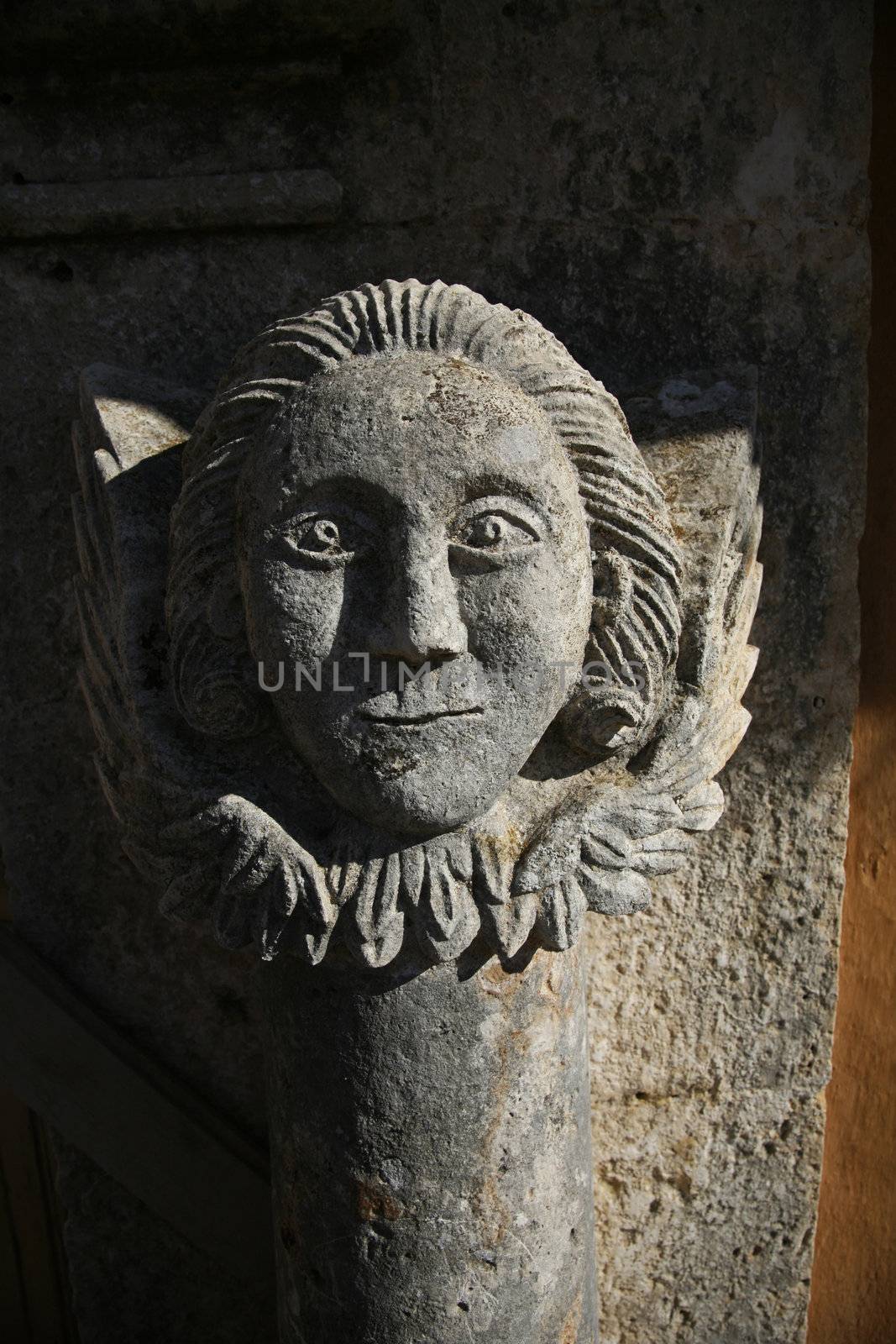 stone sculpture of a man face smiling 