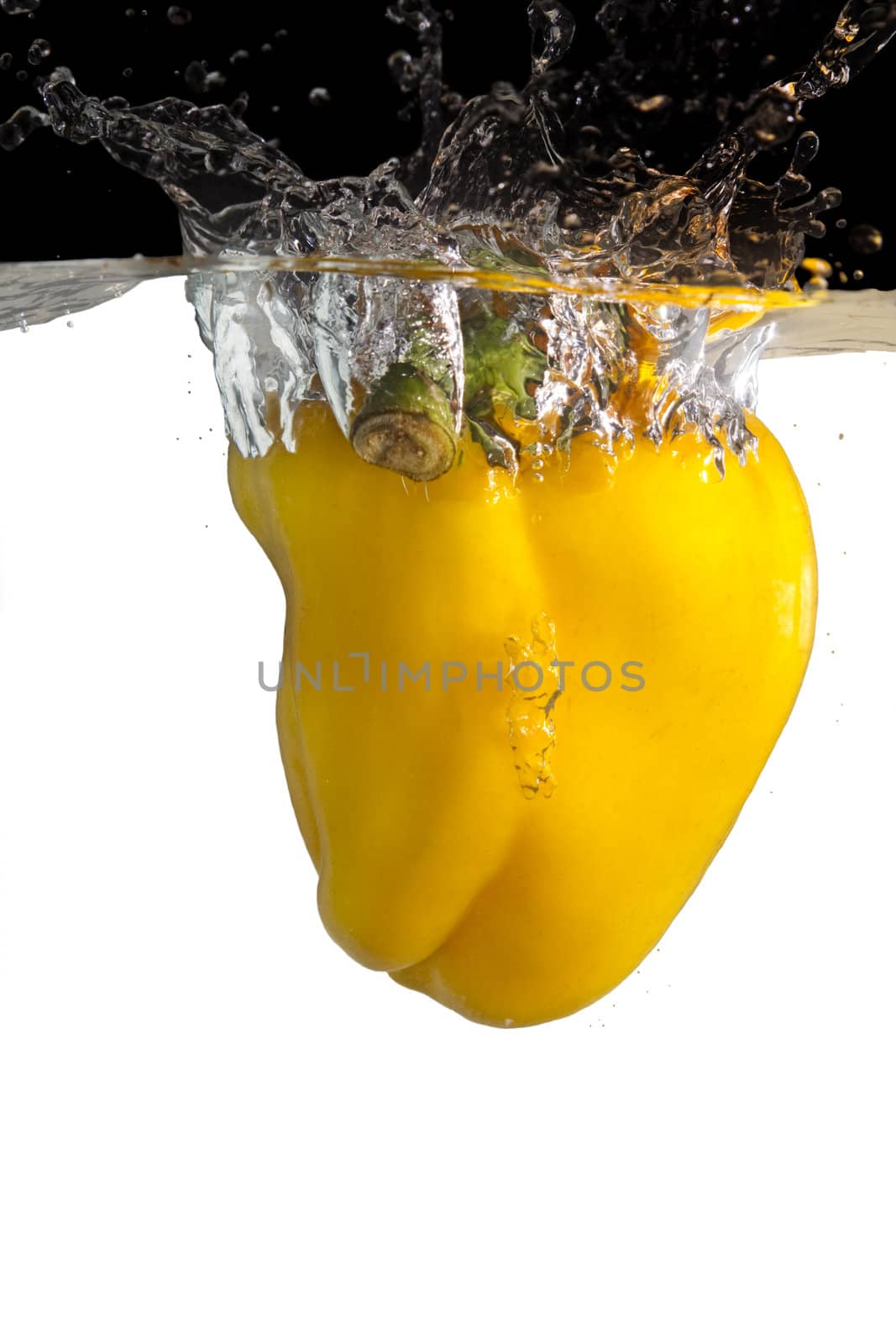 one yellow paprika thrown in water with black and white background