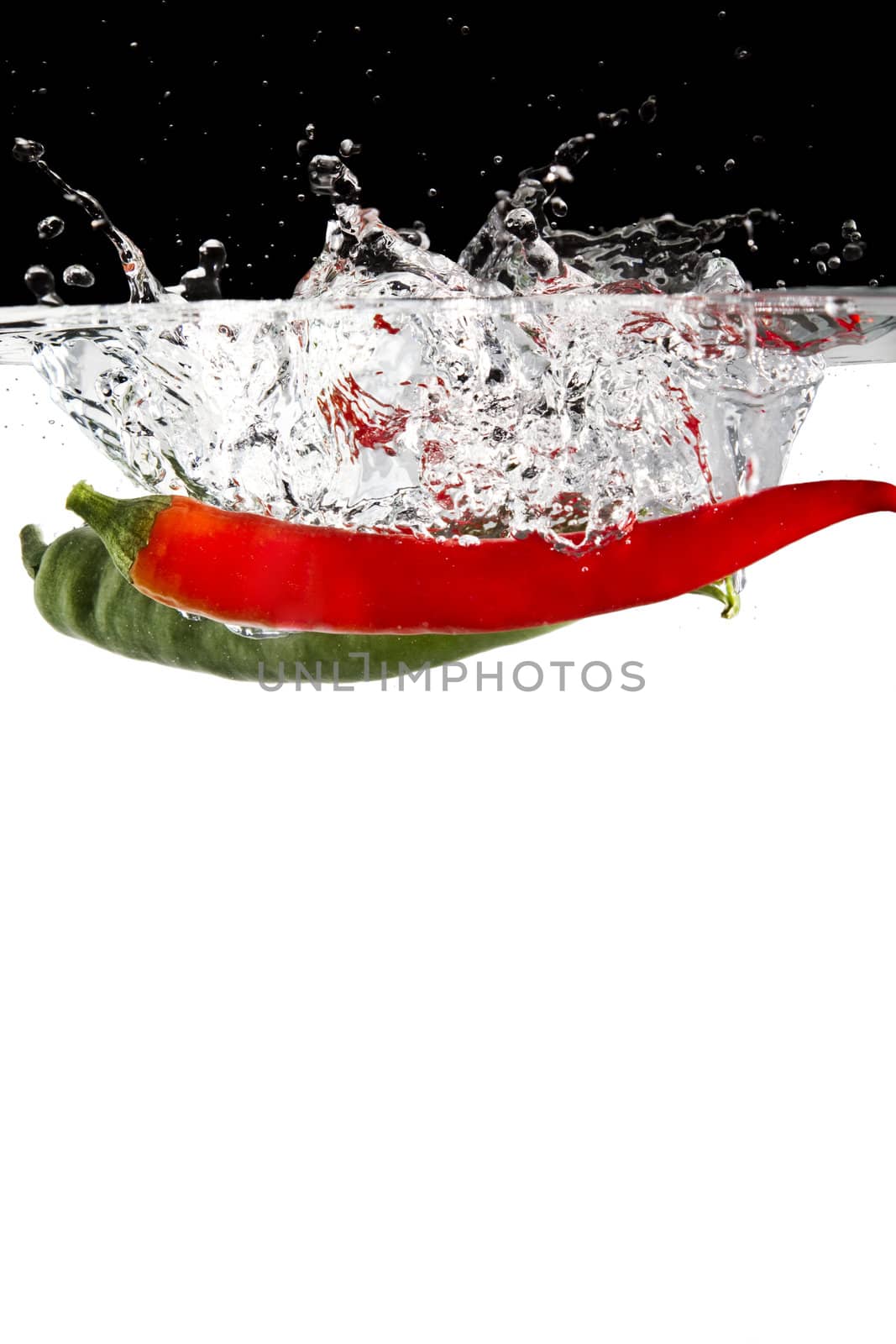 red and green chilli thrown in water with black and white background