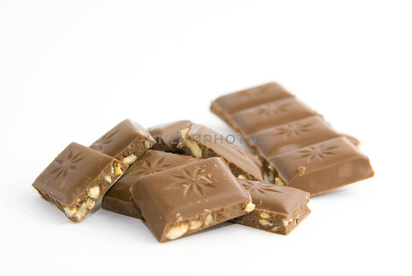Milk chocolate with nuts on white background