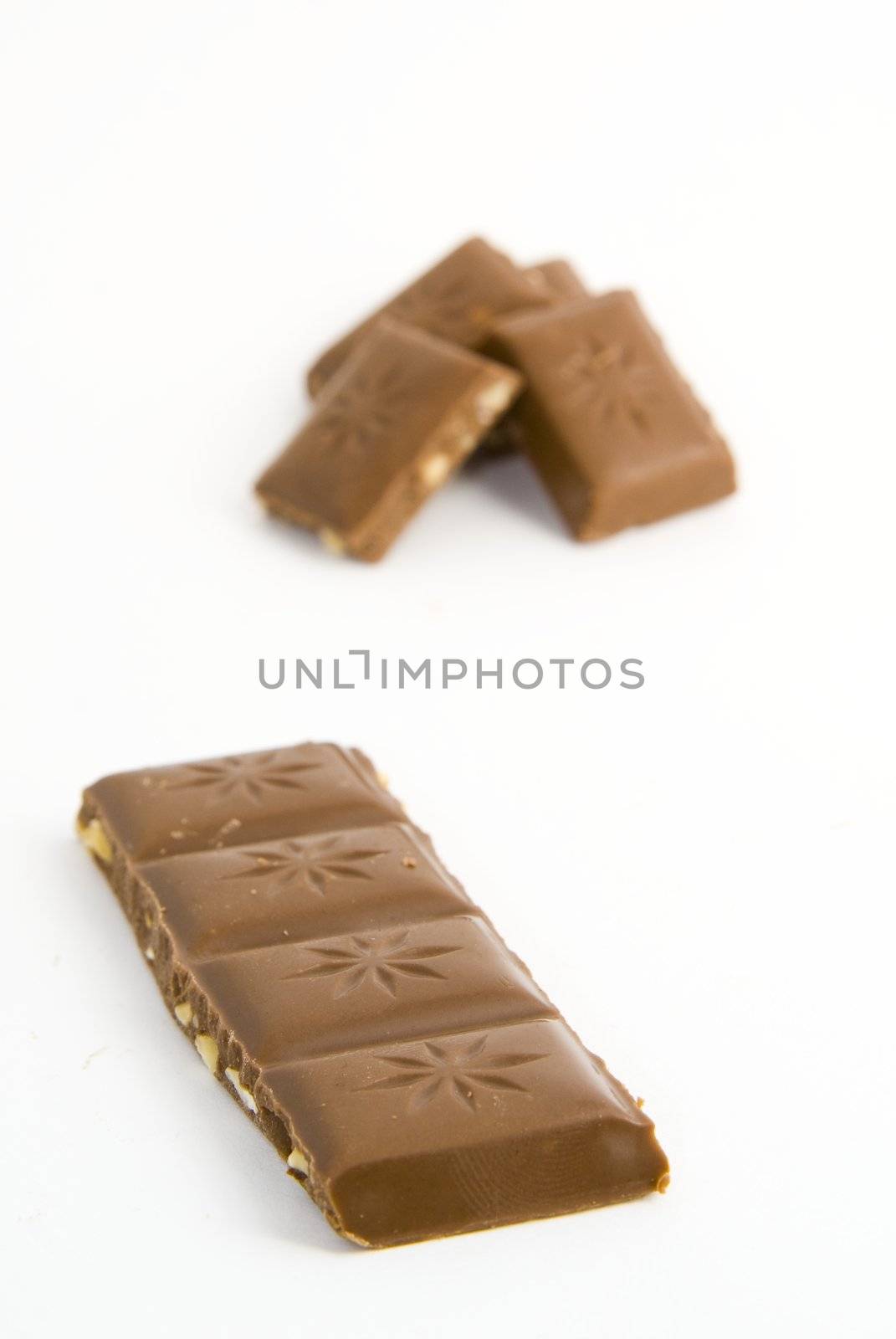 Milk chocolate with nuts on white background