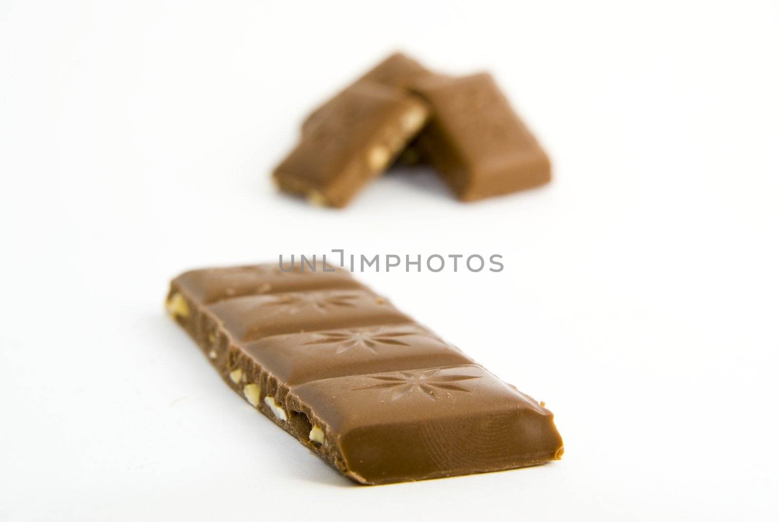 Milk chocolate with nuts on white background