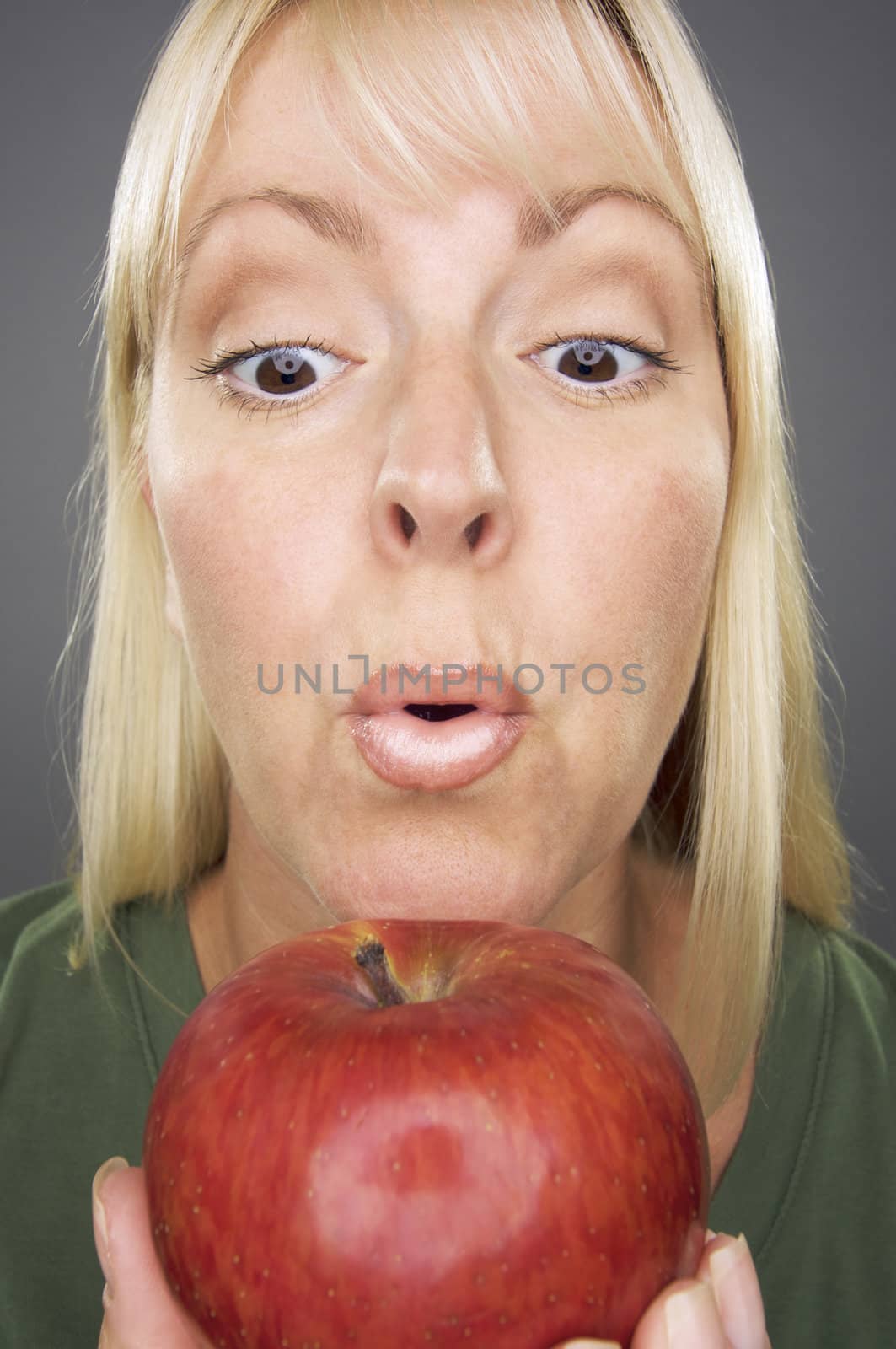 Beautiful Woman With Apple Against A Grey Background