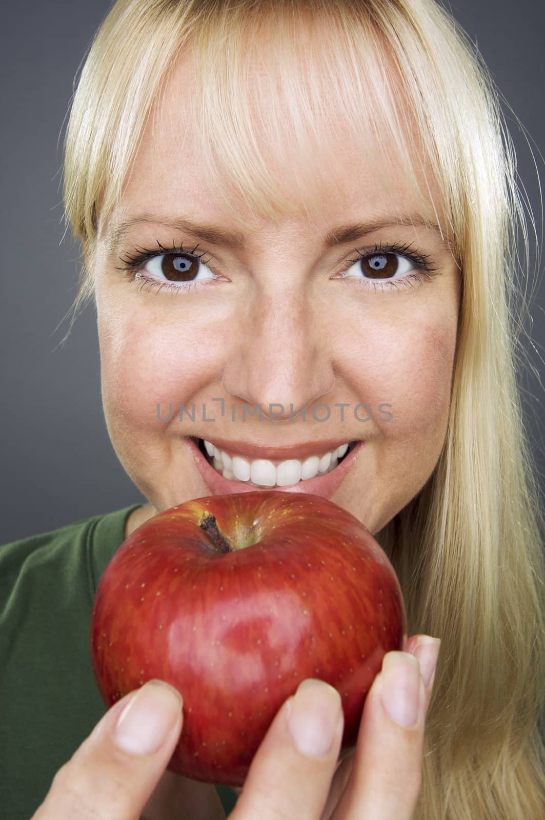 Beautiful Woman With Apple Against A Grey Background