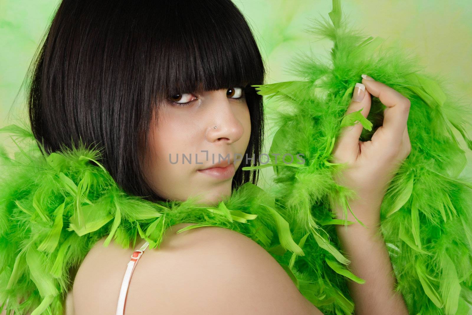 portrait of pretty teen girl with green feather boa