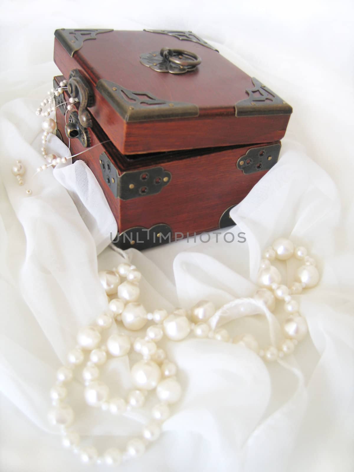 Casket of of pearl necklace on white material