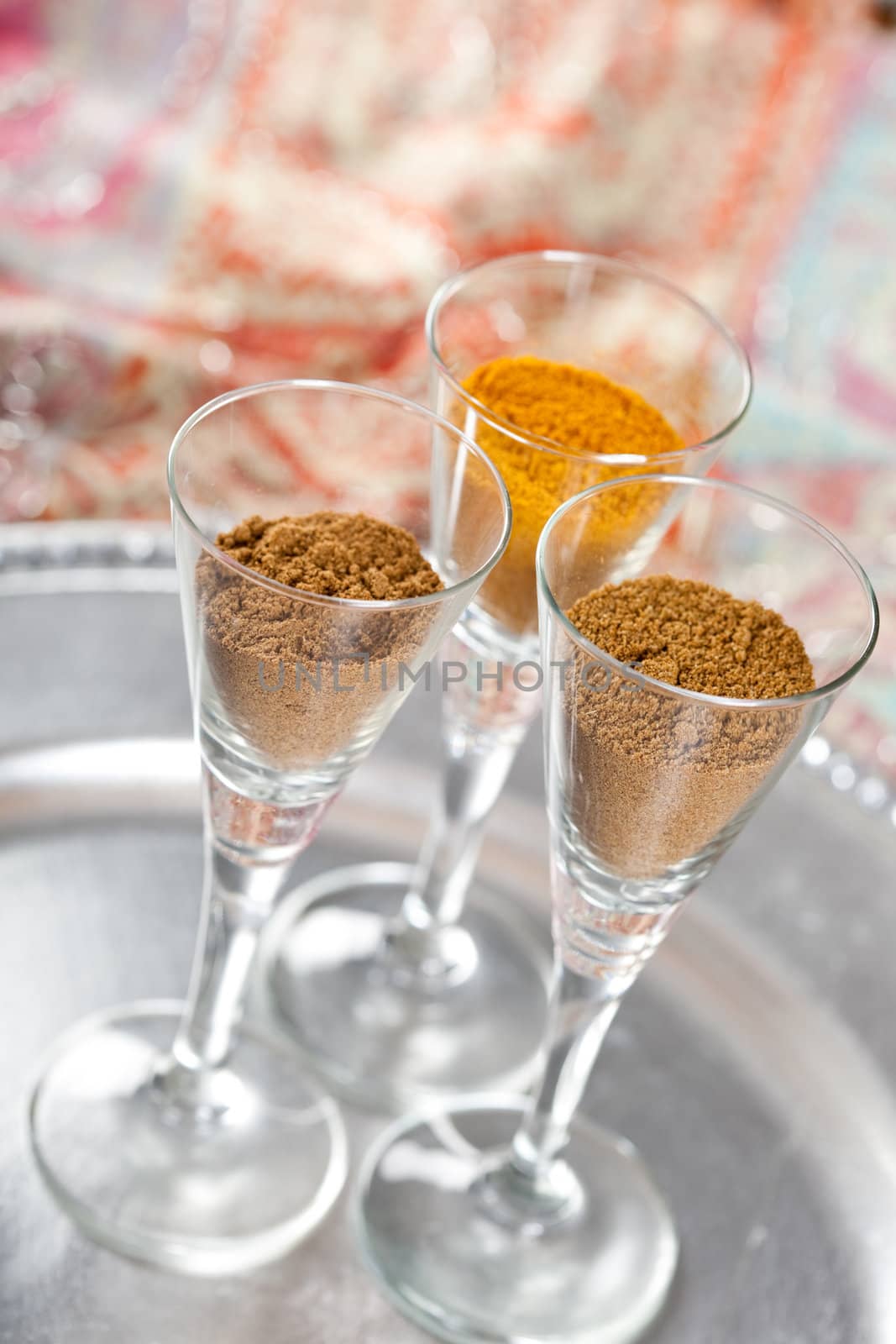 Three small glasses filled with various hot spices used for Indian curries