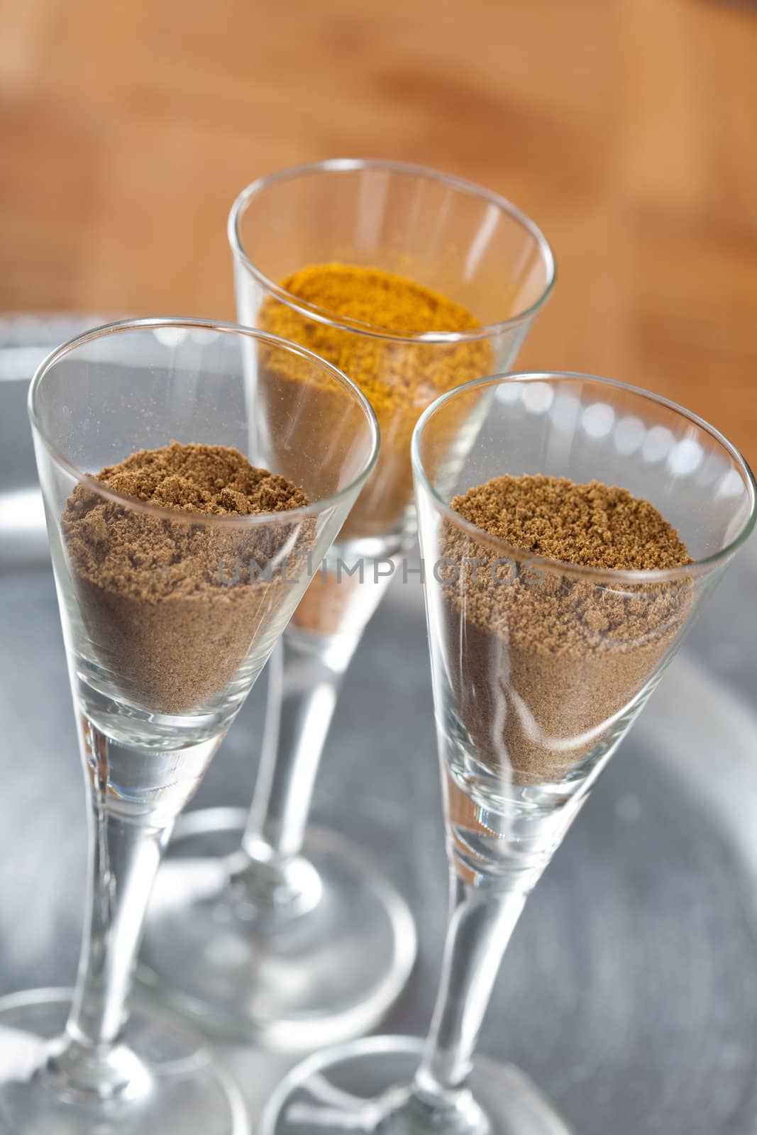 Three types of dried ground spices in small glasses