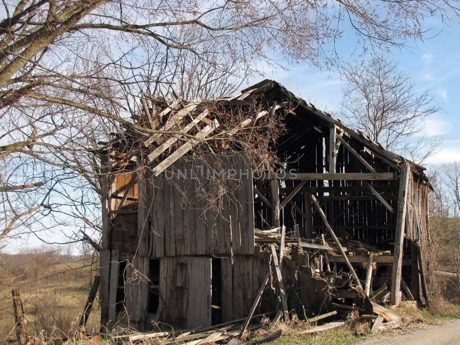 an old falling-down barn on a hill top in the countryside on a sunny day