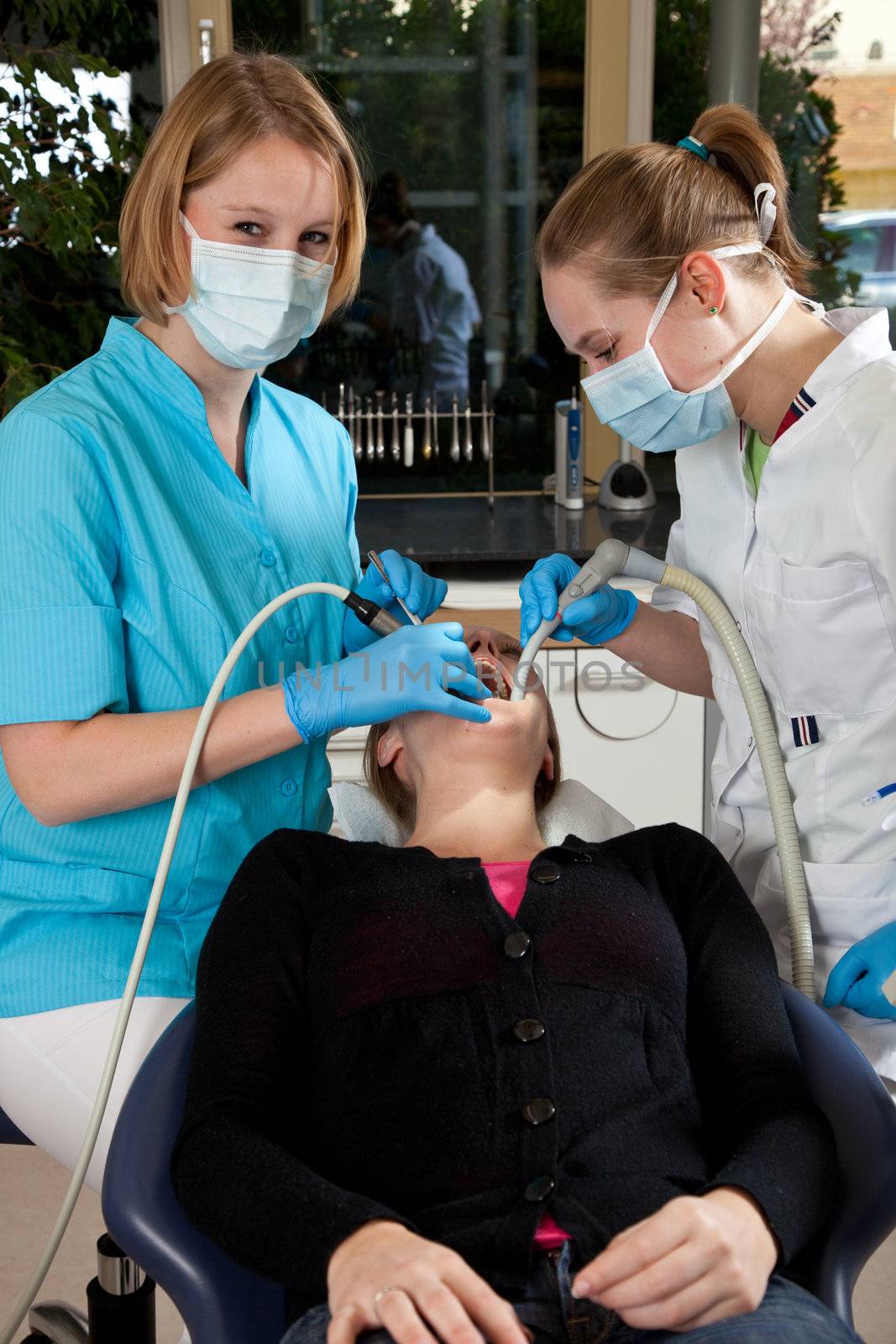 Dentist and her assistent working on a patient