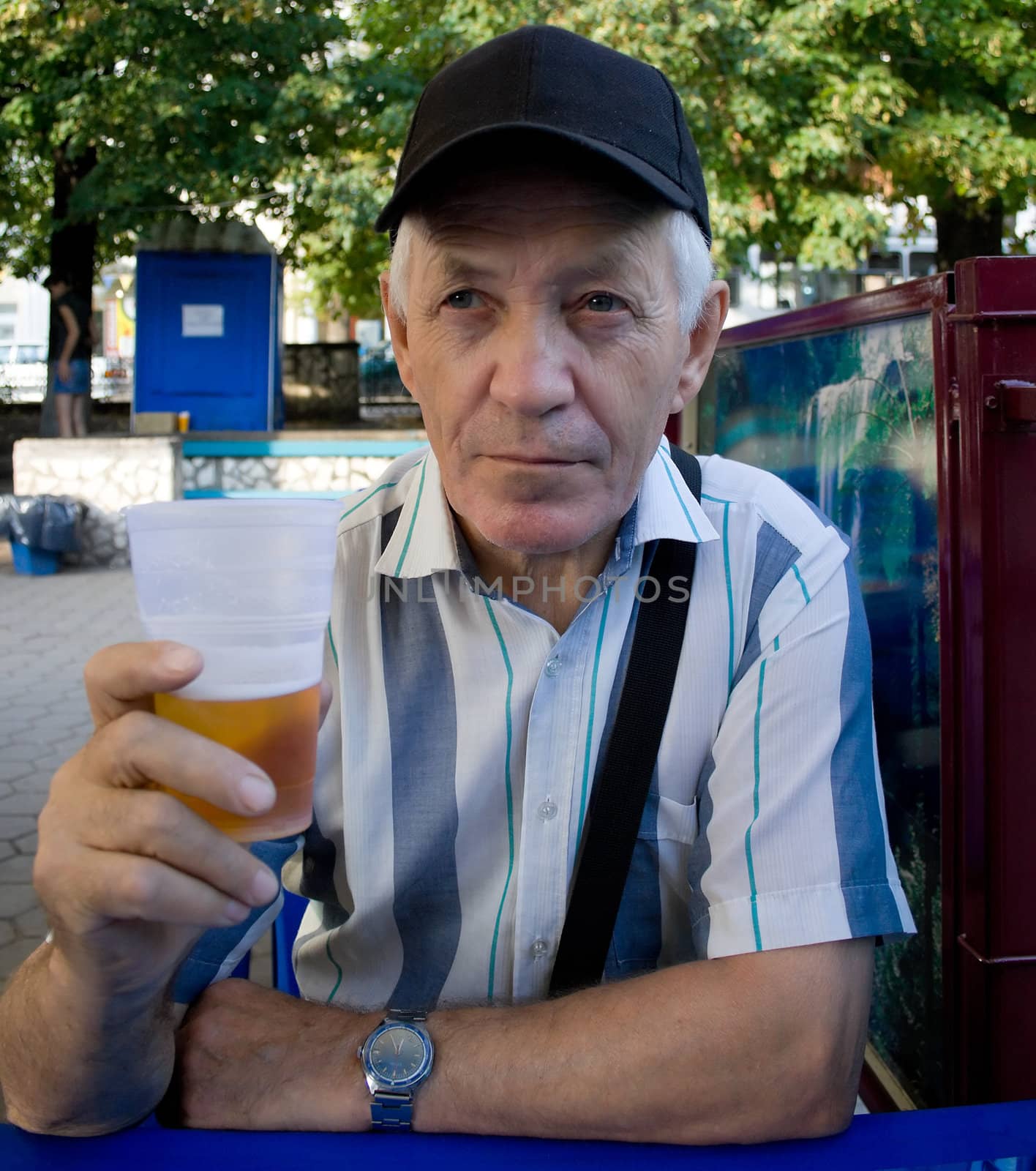 The elderly man with beer in park. A portrait